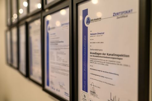 Eine Wand mit vielen Zertifikaten und Auszeichnungen