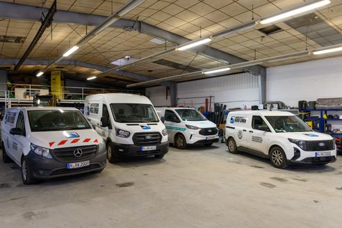 Vier Fahrzeuge mit Abwassertechnik Nord Logo in einer Halle